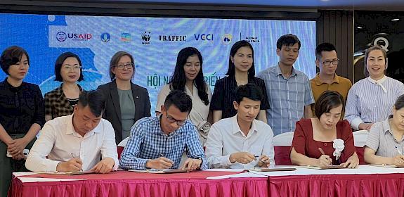 Tourism industry representatives signing a pledge to tackle illegal wildlife trade.